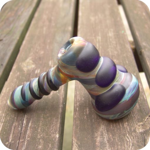 Hammer style glass bubbler featuring full-color jewel-toned glass and decorative elements on the outside