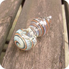 Hand blown, silver fumed, color changing glass pipe with colored stripes spiraled around its puffed out body and tapered mouthpiece